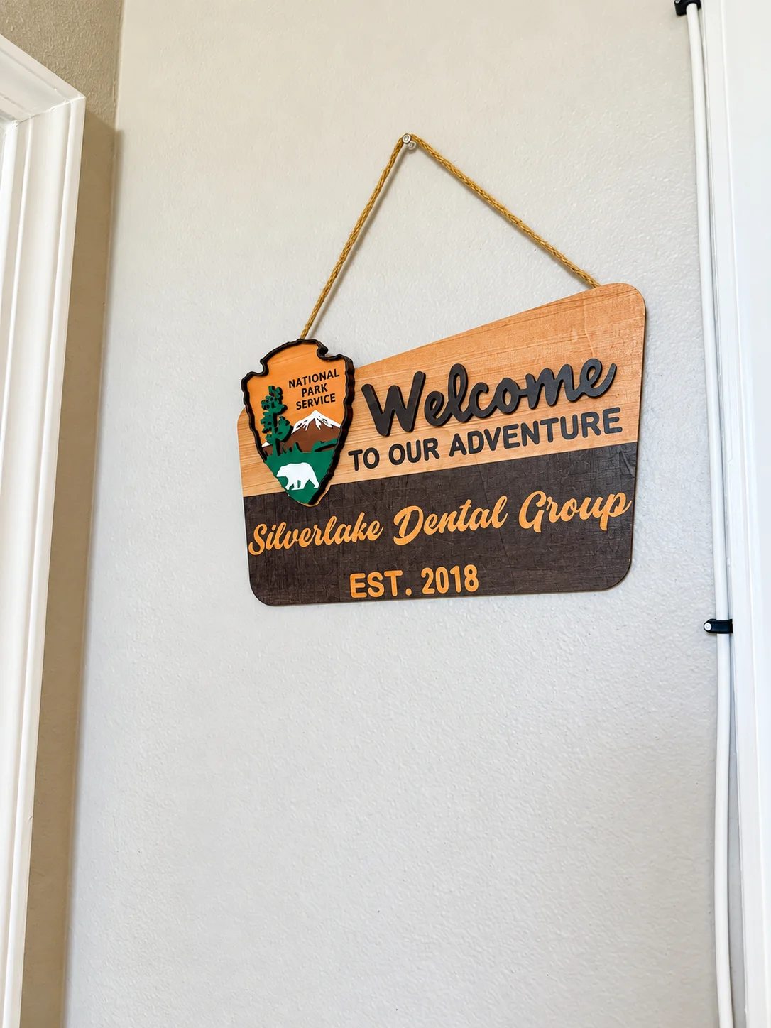 Wooden “Welcome to our adventure” sign for Silverlake Dental Group, est. 2018